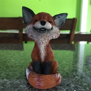 Grinning sly fox figurine